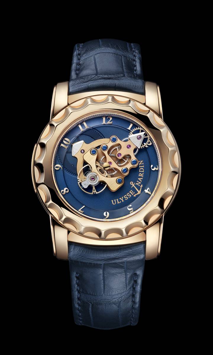 Ulysse Nardin Freak 02, réf. 026-88 (2005). Deuxième version de cette montre révolutionnaire présentée en 2001. L'extrémité triangulaire du mouvement en ligne permet l'indication des heures, une première dans l'histoire de l'horlogerie. L'échappement Dual Ulysse à impulsion directe et sans lubrification est en silicium, une innovation pour l'époque. Sans couronne, la mise à l'heure s'effectue par la lunette rotative, tandis que le ressort de barillet se recharge par le fond de la boîte.