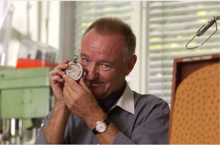 Portrait de Peter Baumberger tenant entre les mains son modèle préféré de Urban Jürgensen, la Tourbillon ovale, et une référence 3 au poignet.