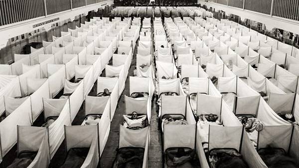 Zone de confinement dans une caserne de San Francisco. Les lits sont équipés de parois anti-éternuements. 1918.
