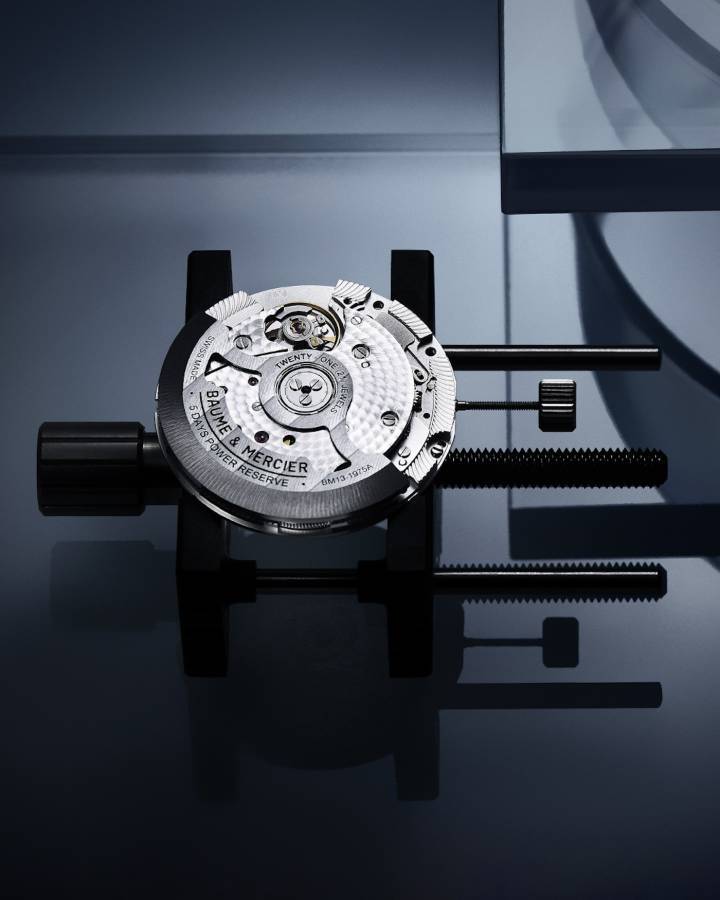 Le calibre Baumatic conçu par Baume & Mercier offre une résistance aux champs magnétiques du quotidien jusqu'à 1'500 Gauss, une fréquence de 4Hz (28'800 vph) et une réserve de marche de 5 jours (120 heures). Les ponts sont perlés, la platine est sablée et colimaçonnée et la masse oscillante avec décors Côtes de Genève colimaçonnés est ajourée. 