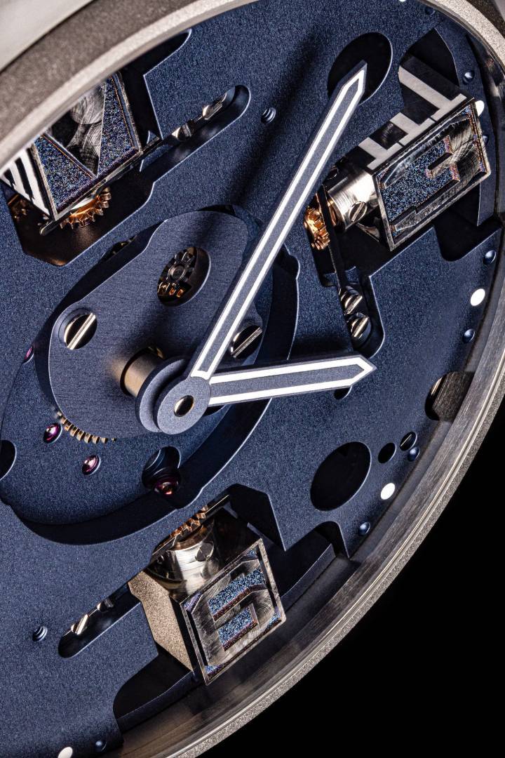 Détail de la nouvelle collection Meca Blue. Le cadran ouvert permet d'apprécier la complexité des mécanismes pivotants des index en chiffres arabes en titane brossé.