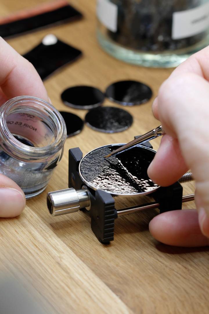 À l'atelier, pose de l'émail avant le passage au four.