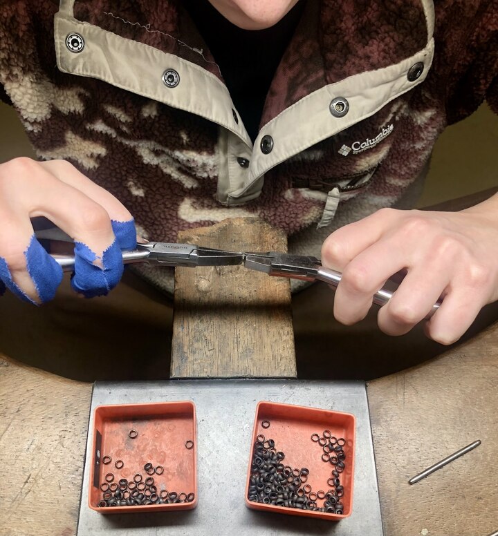 Mise à la taille de maillons. Le geste répété inlassablement provoque de nombreuses cloques et ampoules, comme en témoignent les rubans de protection bleus de la jeune chaîniste évoluant dans l'atelier de Laurent Jolliet.