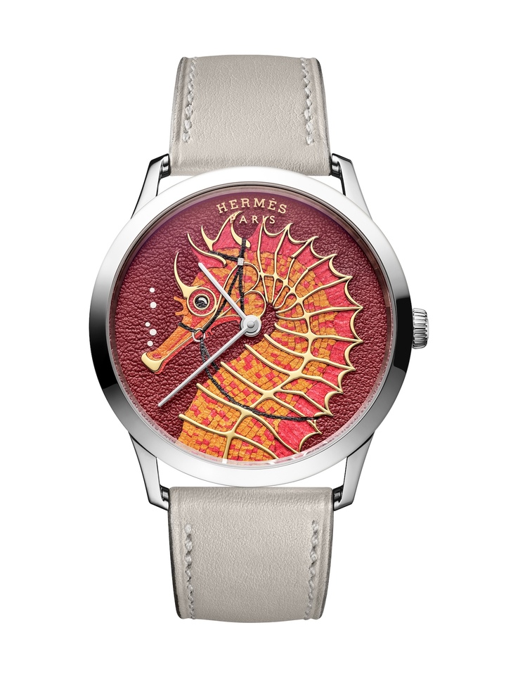 La Slim d'Hermès Hippocampe (2025) a été réalisée en deux exécutions distinctes pour deux éditions limitées et numérotées de 24 exemplaires chacune. Sur cette version, la marqueterie et la mosaïque de cuir dialoguent avec la gravure. L'ossature de l'animal est en effet rehaussée par une applique métallique creusée. À l'instar de l'émaillage champlevé, les tesselles de cuir sont posées autour et entre les filets métalliques. 